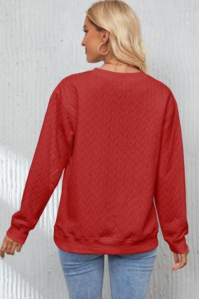 a woman wearing a red sweater and jeans