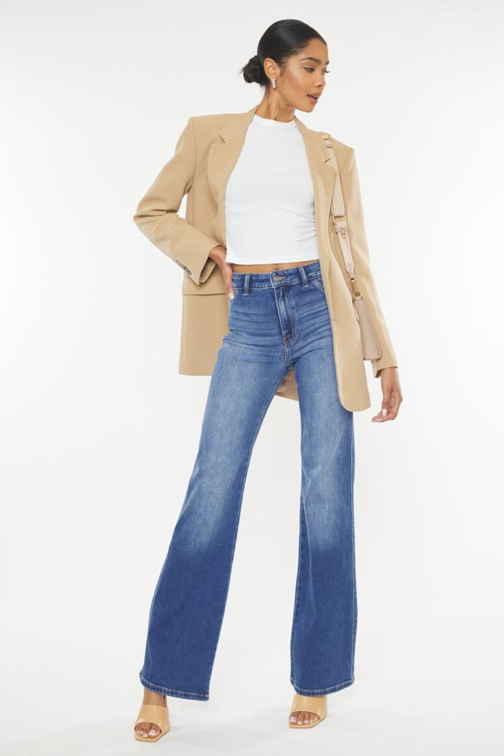 a woman wearing a tan blazer and jeans