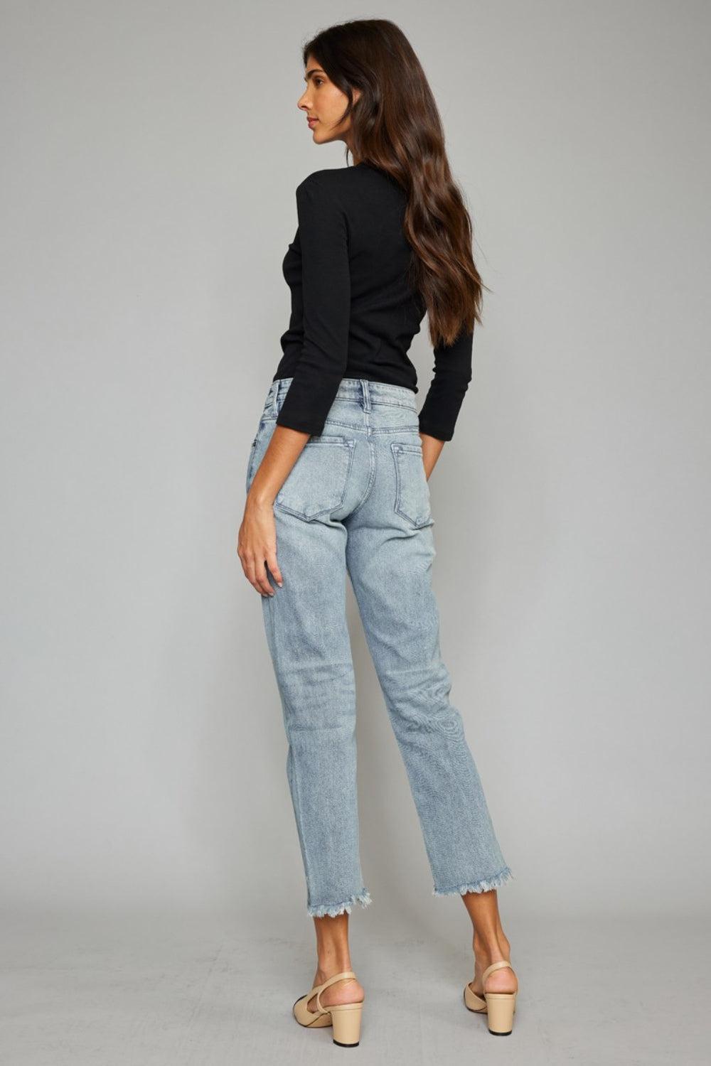 a woman wearing high rise jeans and a black top