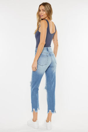 a woman in a grey tank top and blue jeans