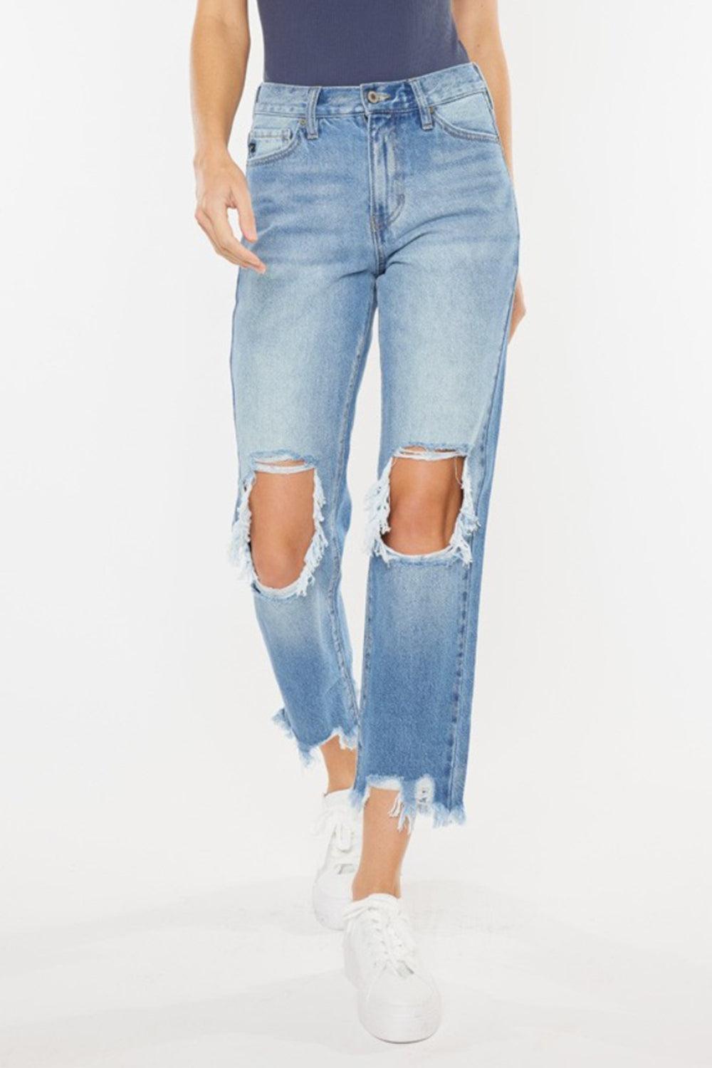 a woman wearing ripped jeans and a tank top