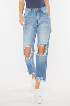a woman wearing ripped jeans and a tank top