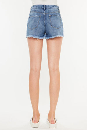 a woman in high rise denim shorts