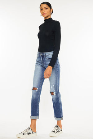 a woman in a black top and ripped jeans