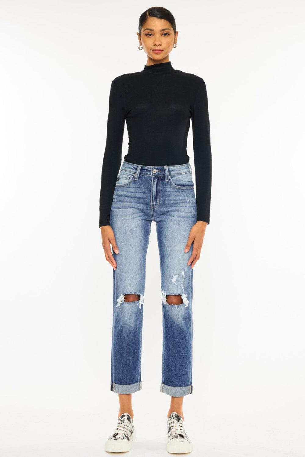 a woman wearing a black turtle neck top and ripped jeans