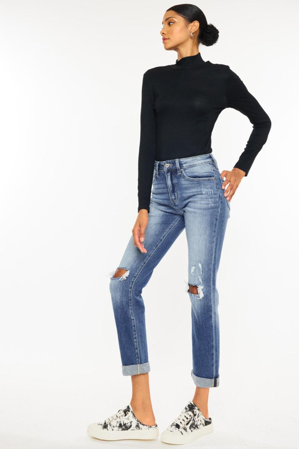 a woman in black shirt and jeans standing with her hands on her hips