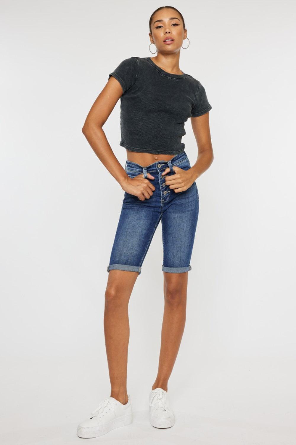 a woman in a black crop top and denim shorts