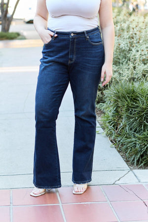 a woman standing on a sidewalk with her hands in her pockets