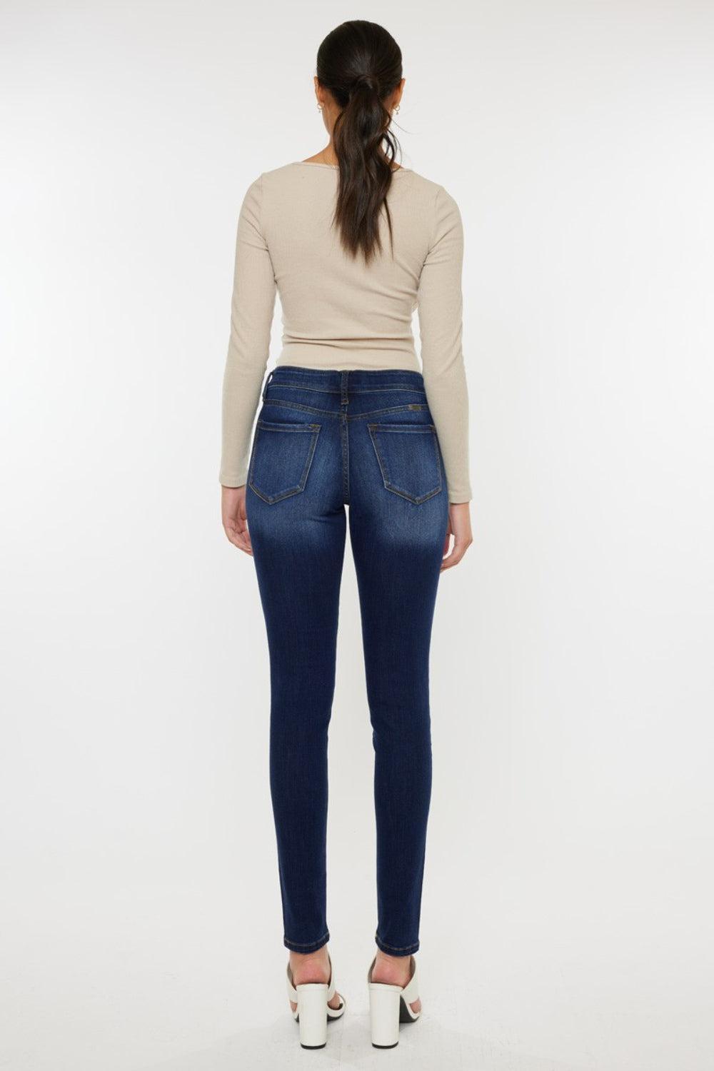 a woman in a beige top and jeans