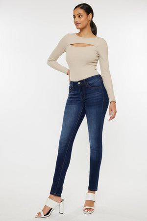 a woman in a beige top and jeans