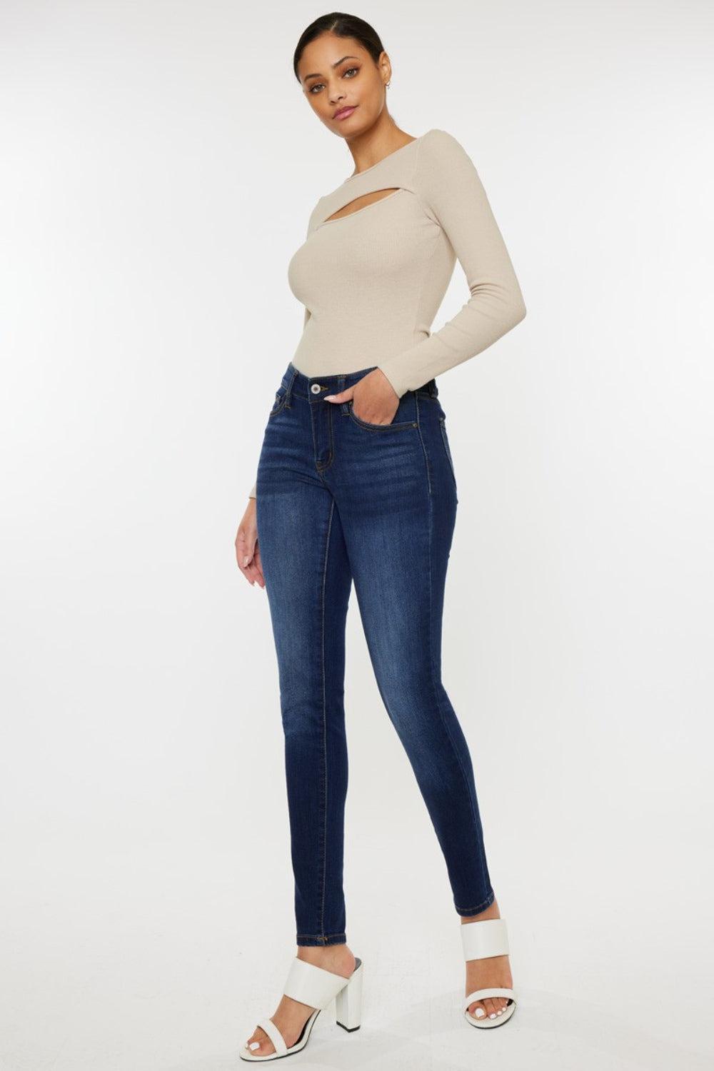 a woman in jeans and heels posing for the camera