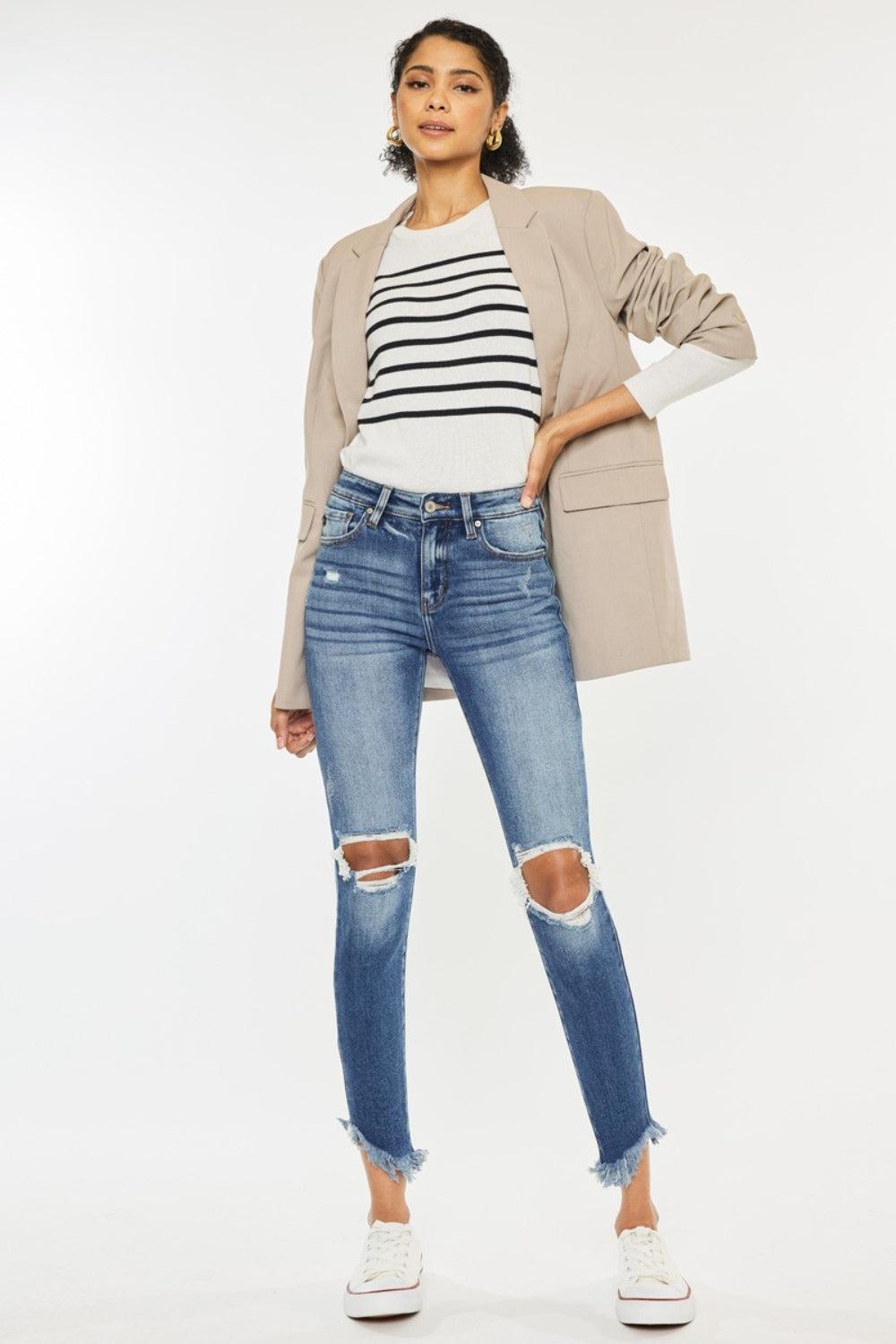 a woman wearing ripped jeans and a striped shirt