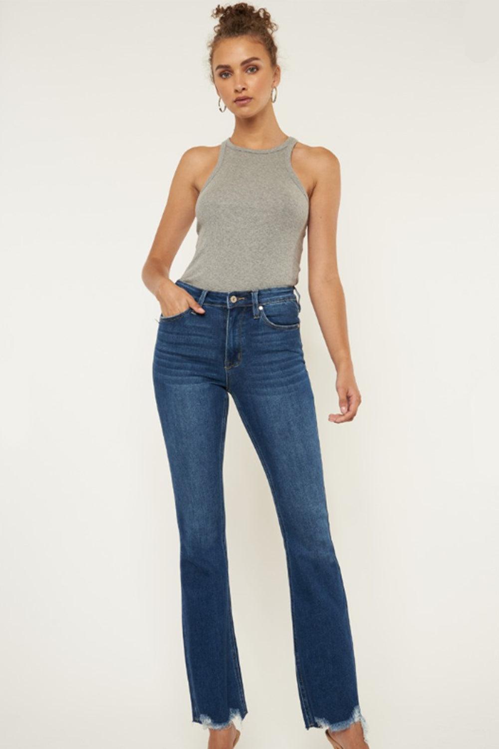 a woman in a grey tank top and jeans
