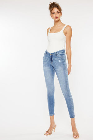 a woman in a white tank top and jeans