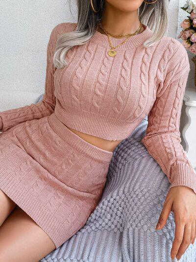 a woman wearing a pink sweater and skirt