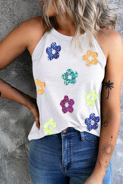 a woman wearing a white top with colorful flowers on it