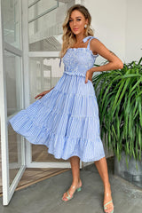 a woman posing in a blue and white striped dress