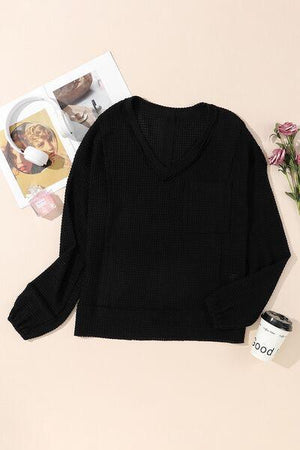 a black sweater and a cup of coffee on a table