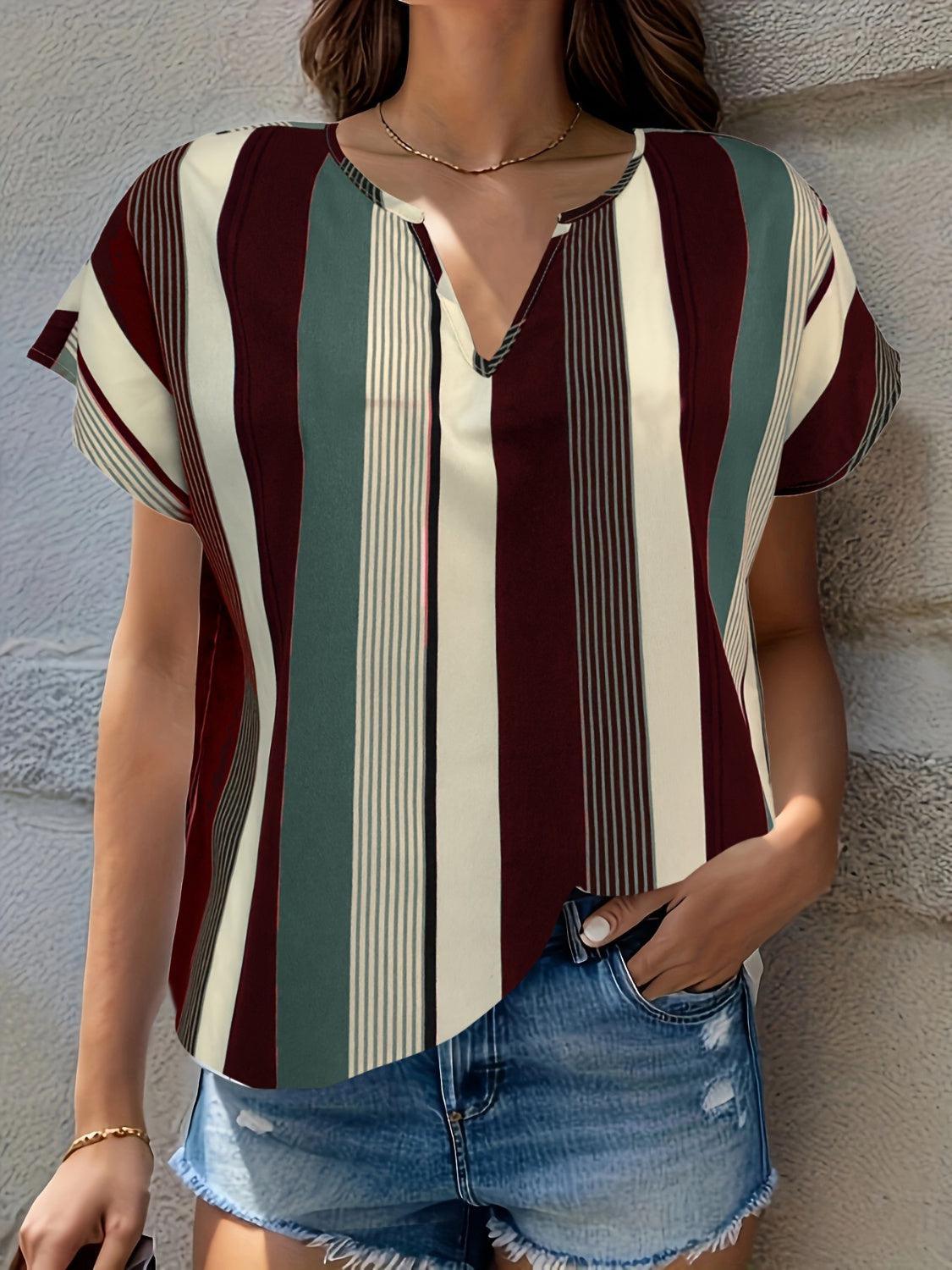 a woman wearing a striped shirt and denim shorts