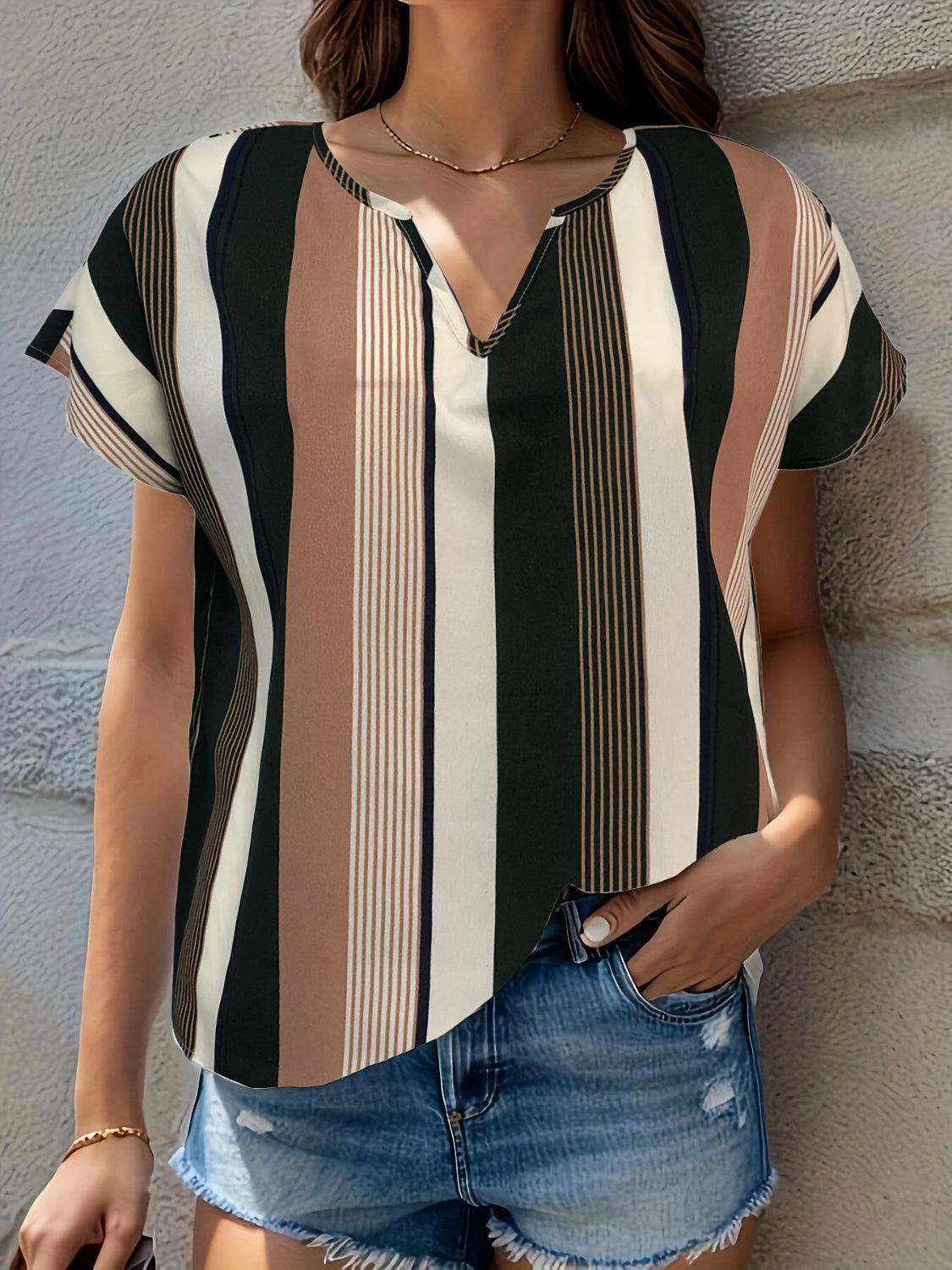 a woman wearing a striped shirt and denim shorts