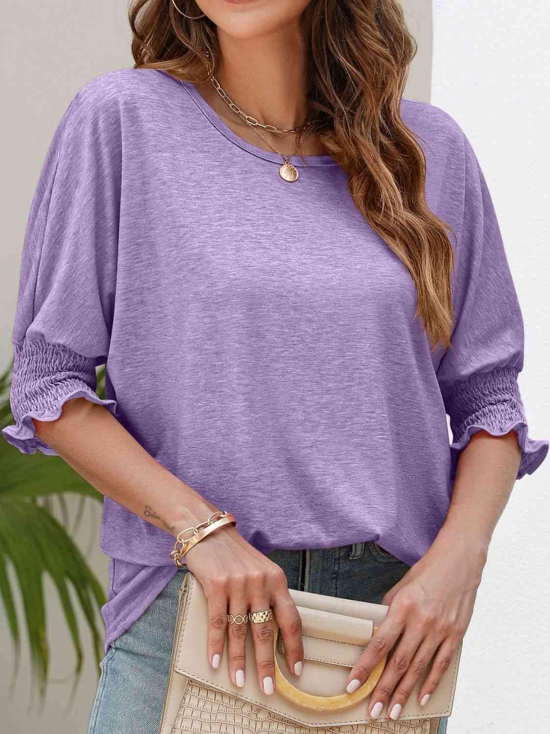 a woman wearing a purple top and jeans