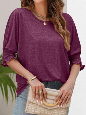 a woman wearing a purple top and jeans