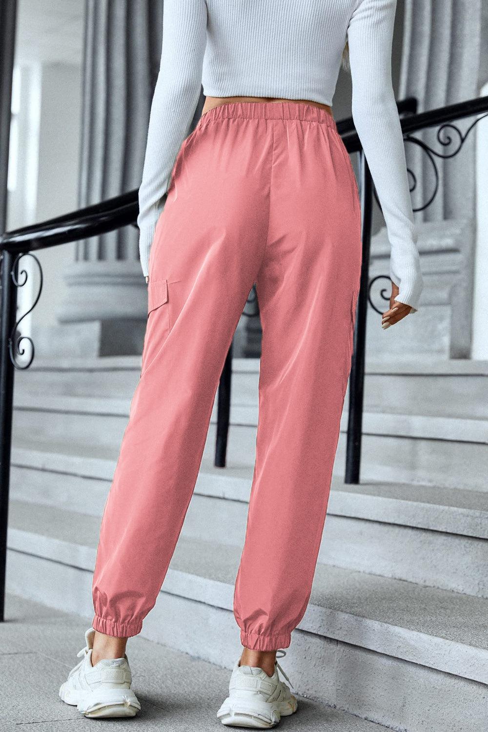 a woman in a white top and pink pants