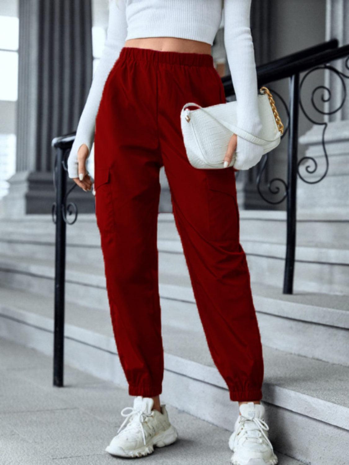 a woman in a white top and red pants