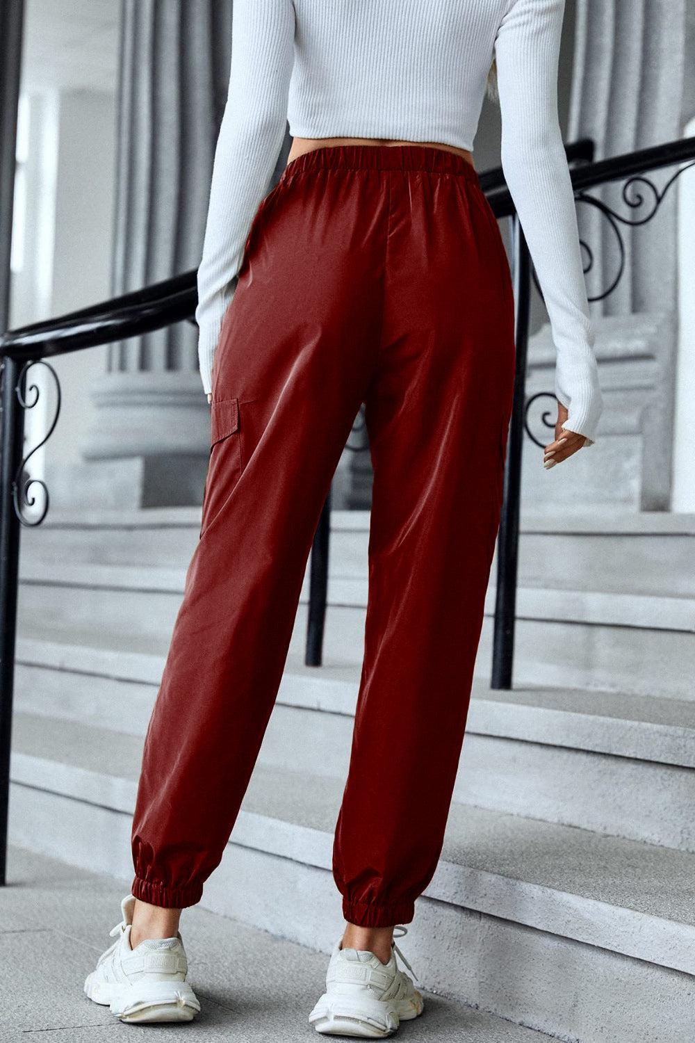 a woman in a white top and red pants