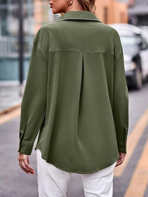 a woman walking down a street wearing a green shirt