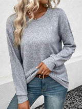 a woman wearing a grey sweater and jeans