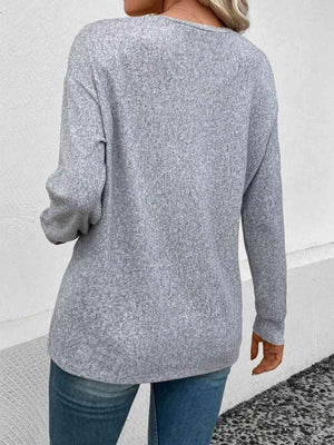 a woman wearing a grey sweater and jeans