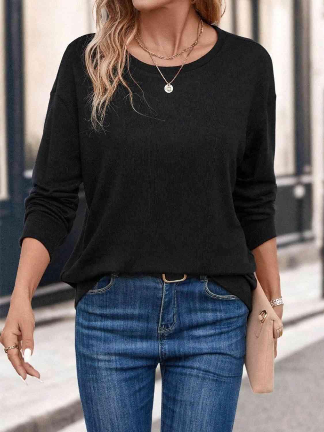 a woman wearing a black sweater and jeans