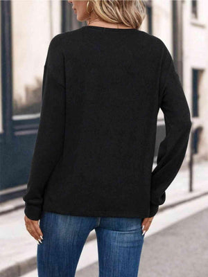 a woman wearing a black sweater and jeans