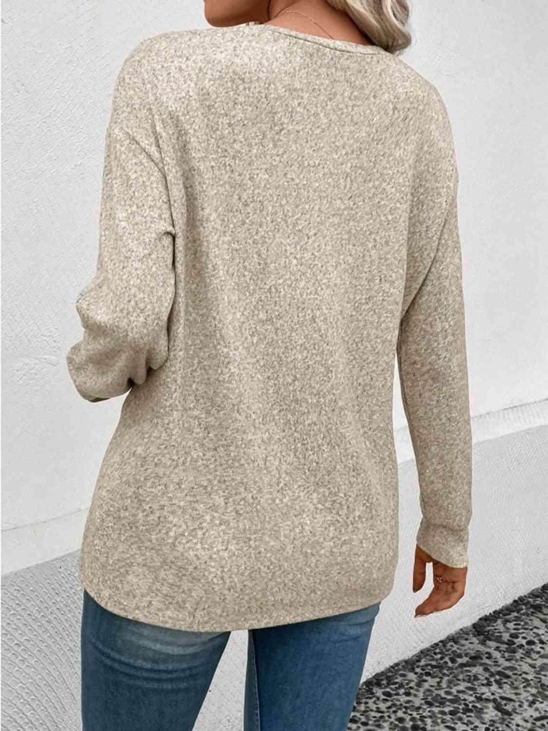 a woman wearing a beige sweater and jeans