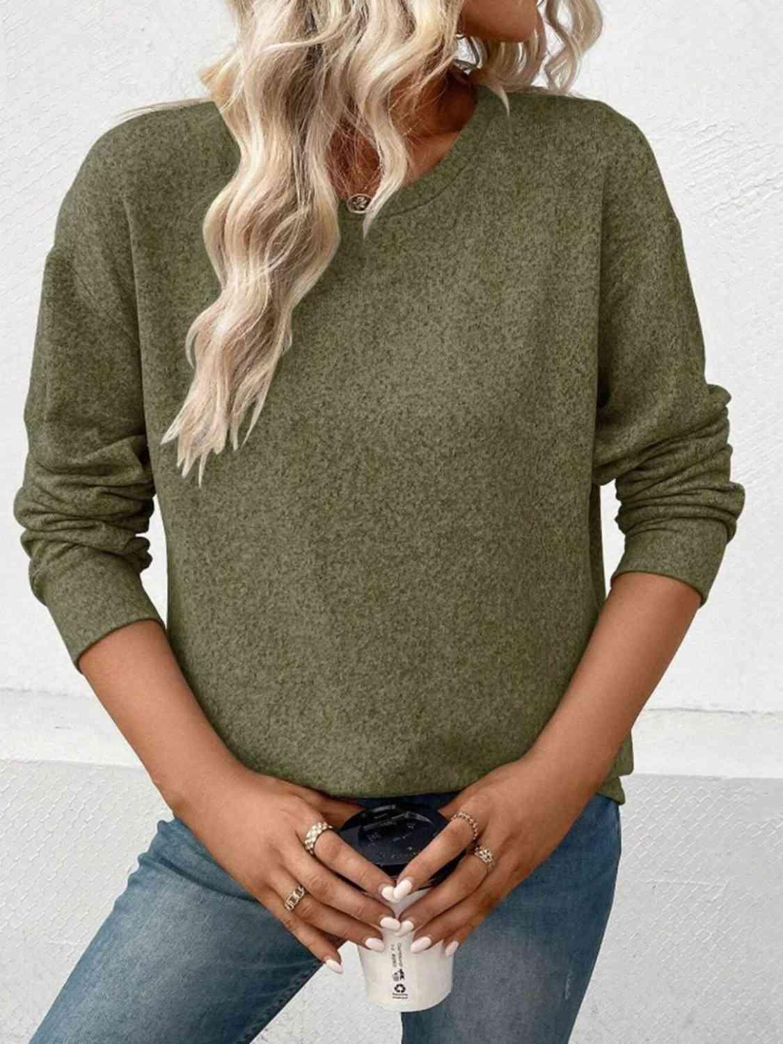 a woman wearing a green sweater and jeans