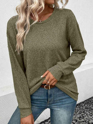 a woman wearing a green sweater and jeans