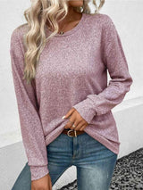 a woman wearing a pink sweater and jeans