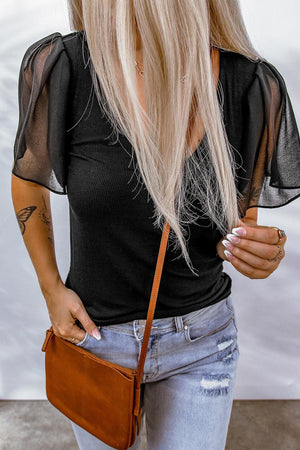 a woman with long blonde hair holding a brown purse