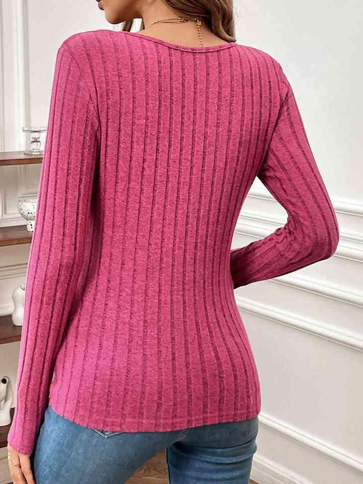 a woman wearing a pink sweater and jeans