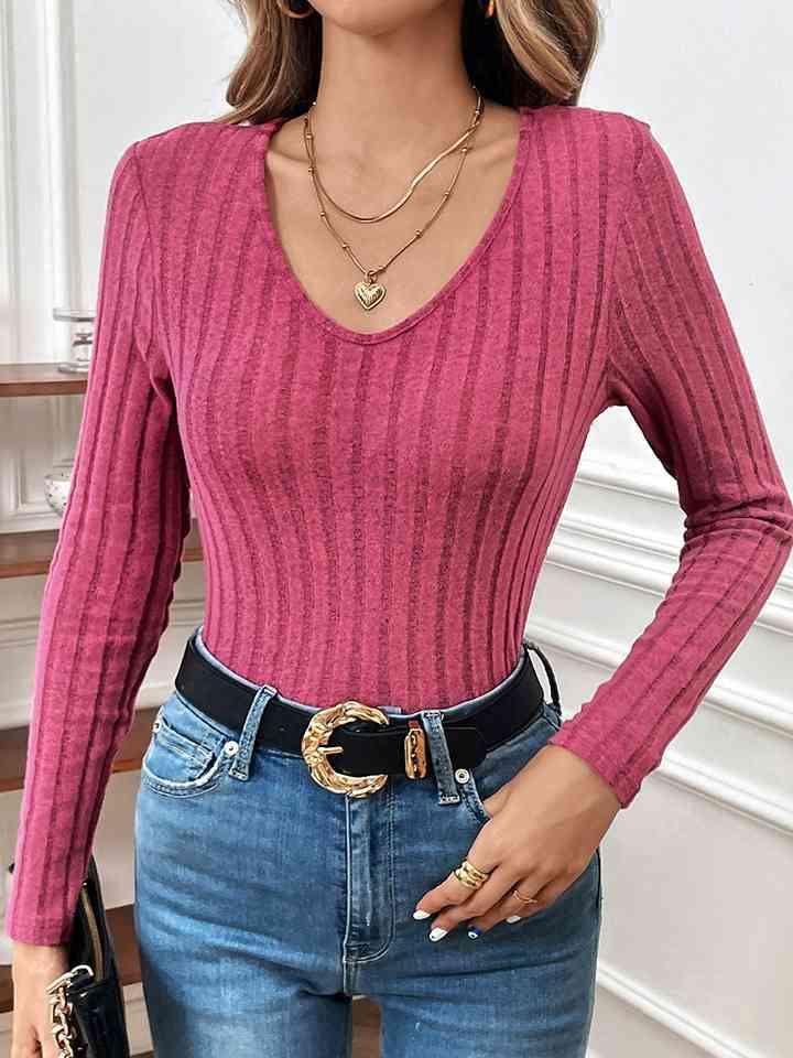 a woman wearing a pink sweater and jeans