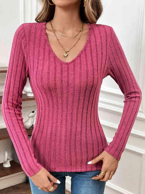 a woman wearing a pink sweater and jeans