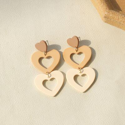 a pair of heart shaped wooden earrings