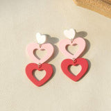 a pair of pink and white heart shaped earrings