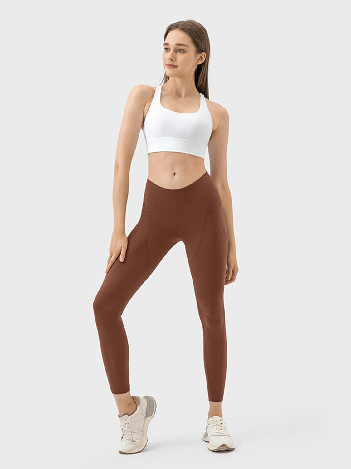 a woman in a white top and brown leggings