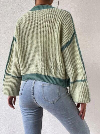 a woman wearing a green sweater and jeans