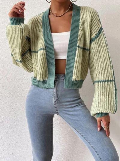 a woman wearing a green cardigan sweater and jeans