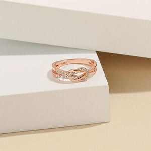 a white box with a pink gold ring on top of it