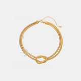 a gold bracelet with a knot on it