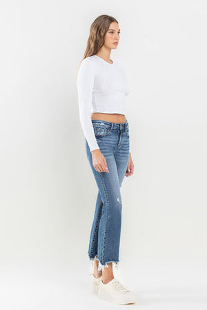 a woman wearing a white crop top and jeans